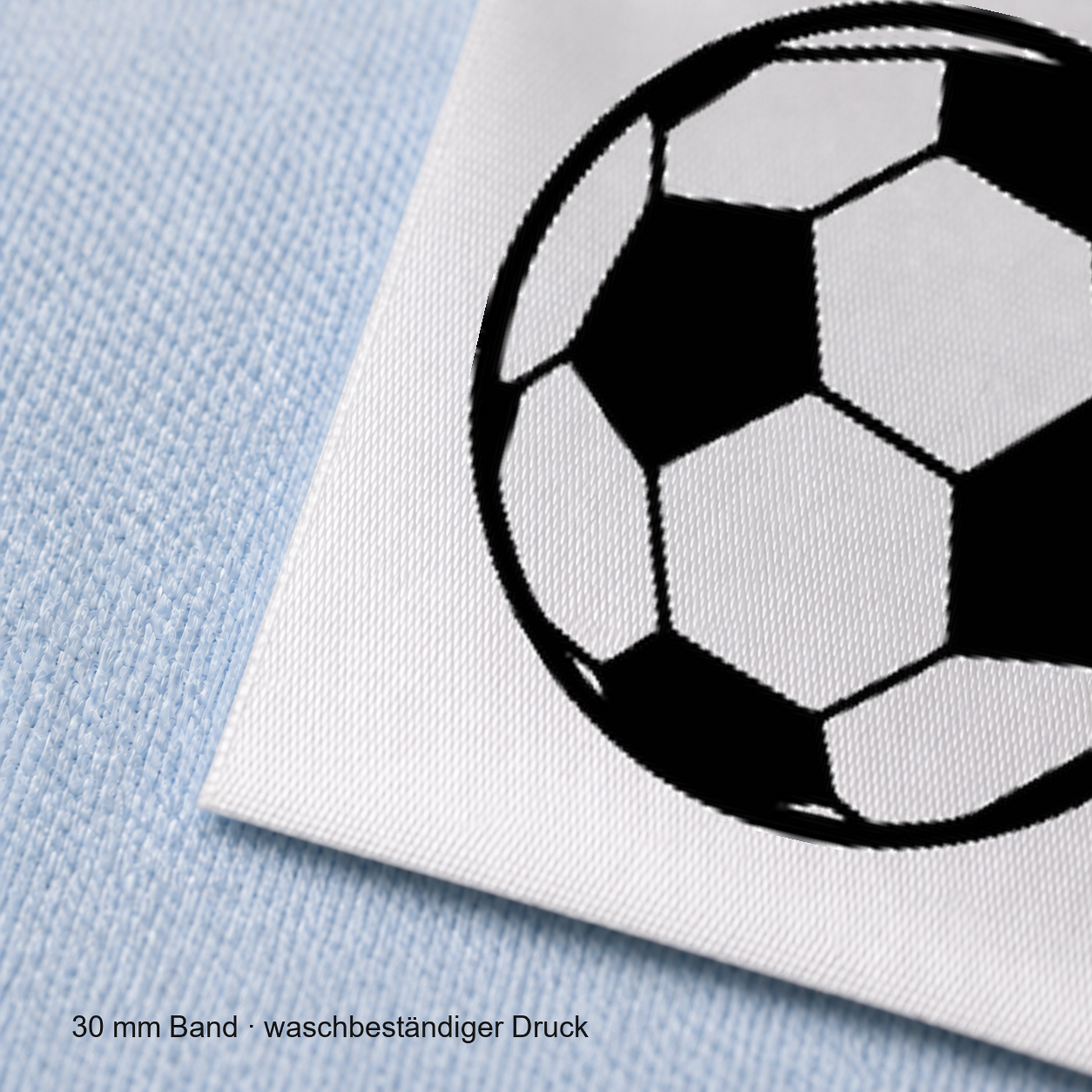 Textiletiketten für Größenbeschriftung mit Fußball Motiv und Größenfeld 6 Nahaufnahme eines bedruckten 30-mm-Polyester-Satinbands mit Motiv Fußball