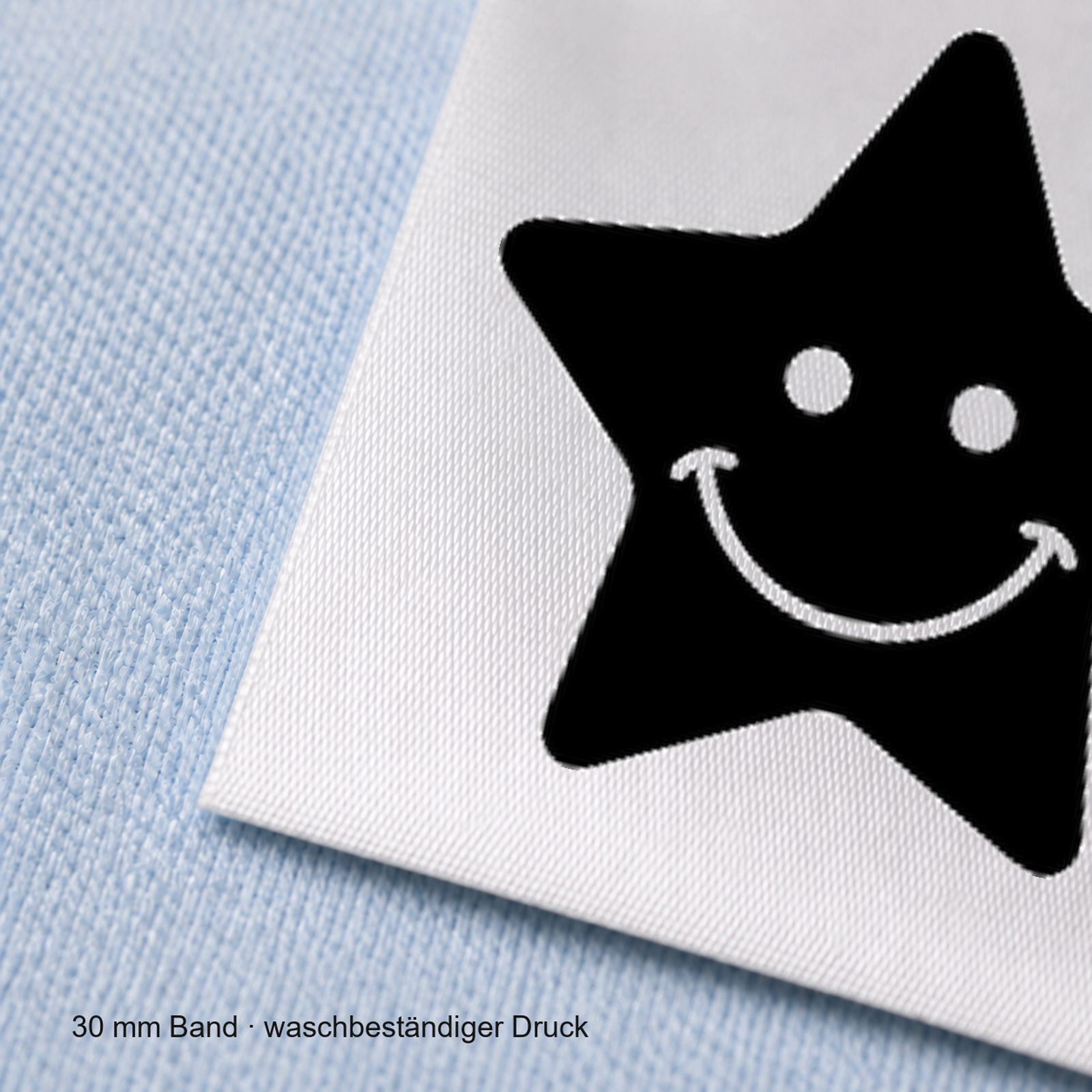 Textiletiketten mit Stern Motiv für Größenbeschriftung 6 Nahaufnahme eines bedruckten 30-mm-Polyester-Satinbands mit Motiv Lachender Stern