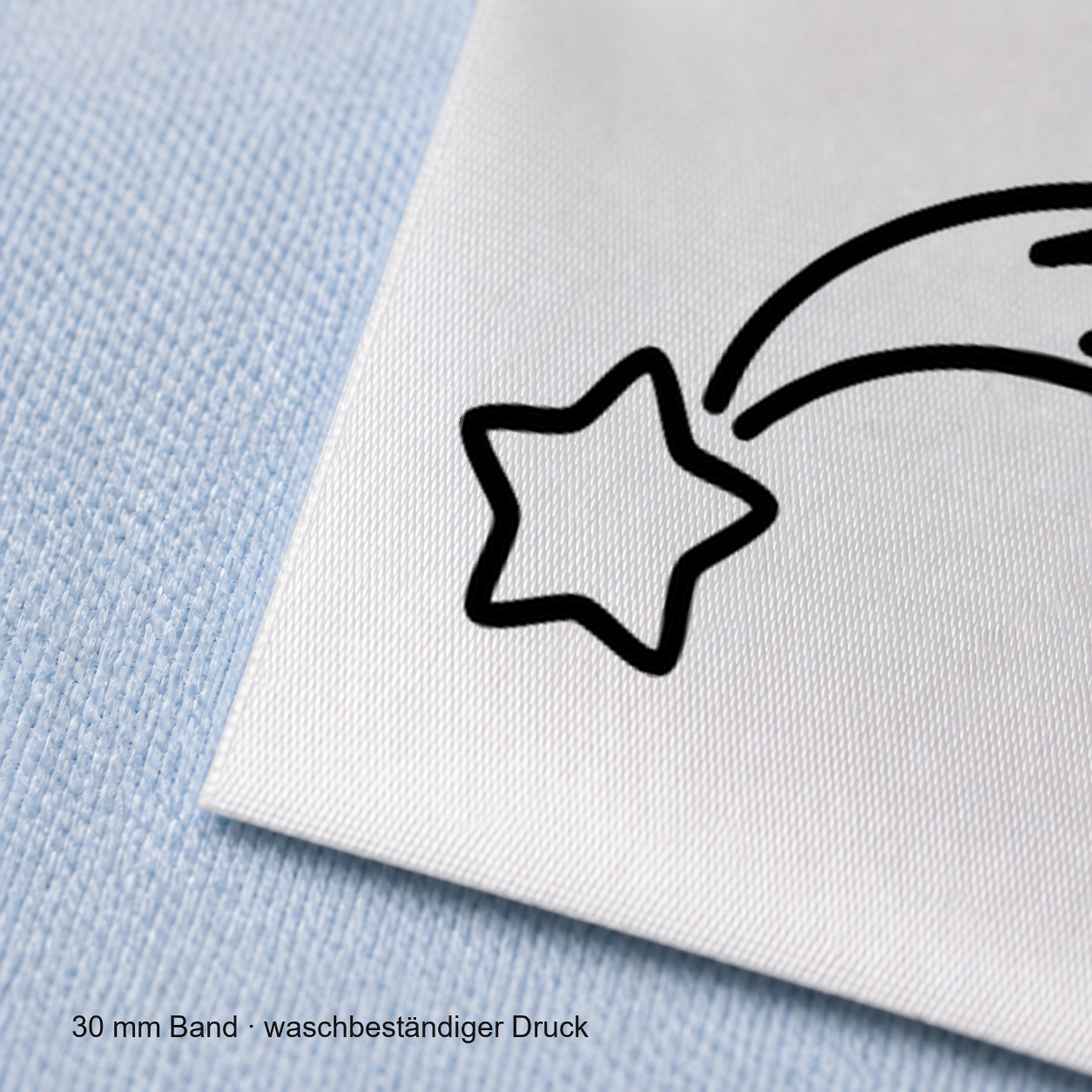 Textiletiketten für Größenbeschriftung mit Sternschnuppe Motiv und Größenfeld 6 Nahaufnahme eines bedruckten 30-mm-Polyester-Satinbands mit Motiv Sternschnuppe