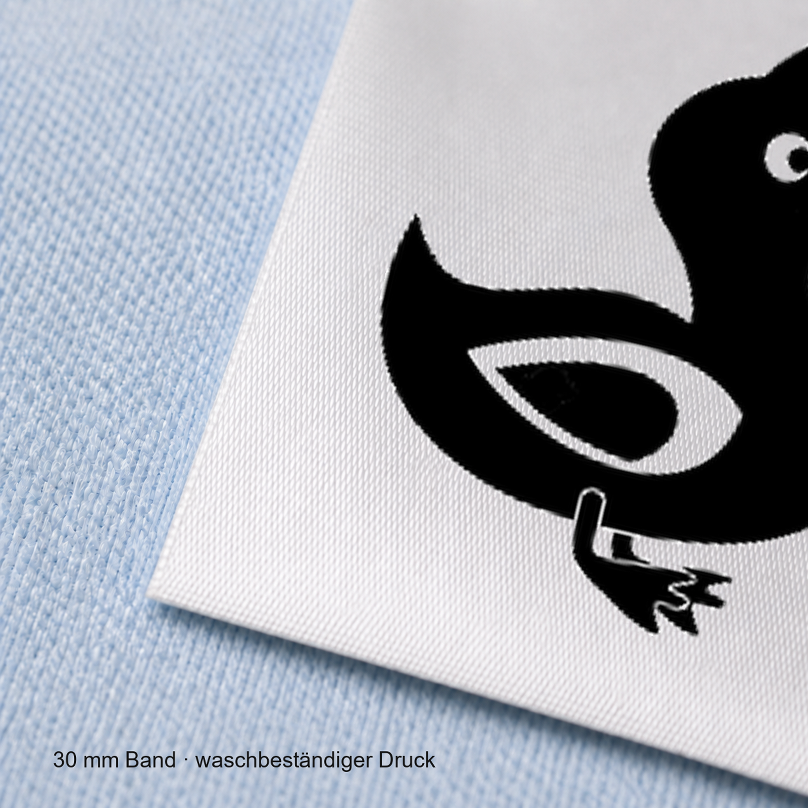 Textiletiketten für Größenbeschriftung mit Enten Motiv und Größenfeld 6 Nahaufnahme eines bedruckten 30-mm-Polyester-Satinbands mit Motiv Ente