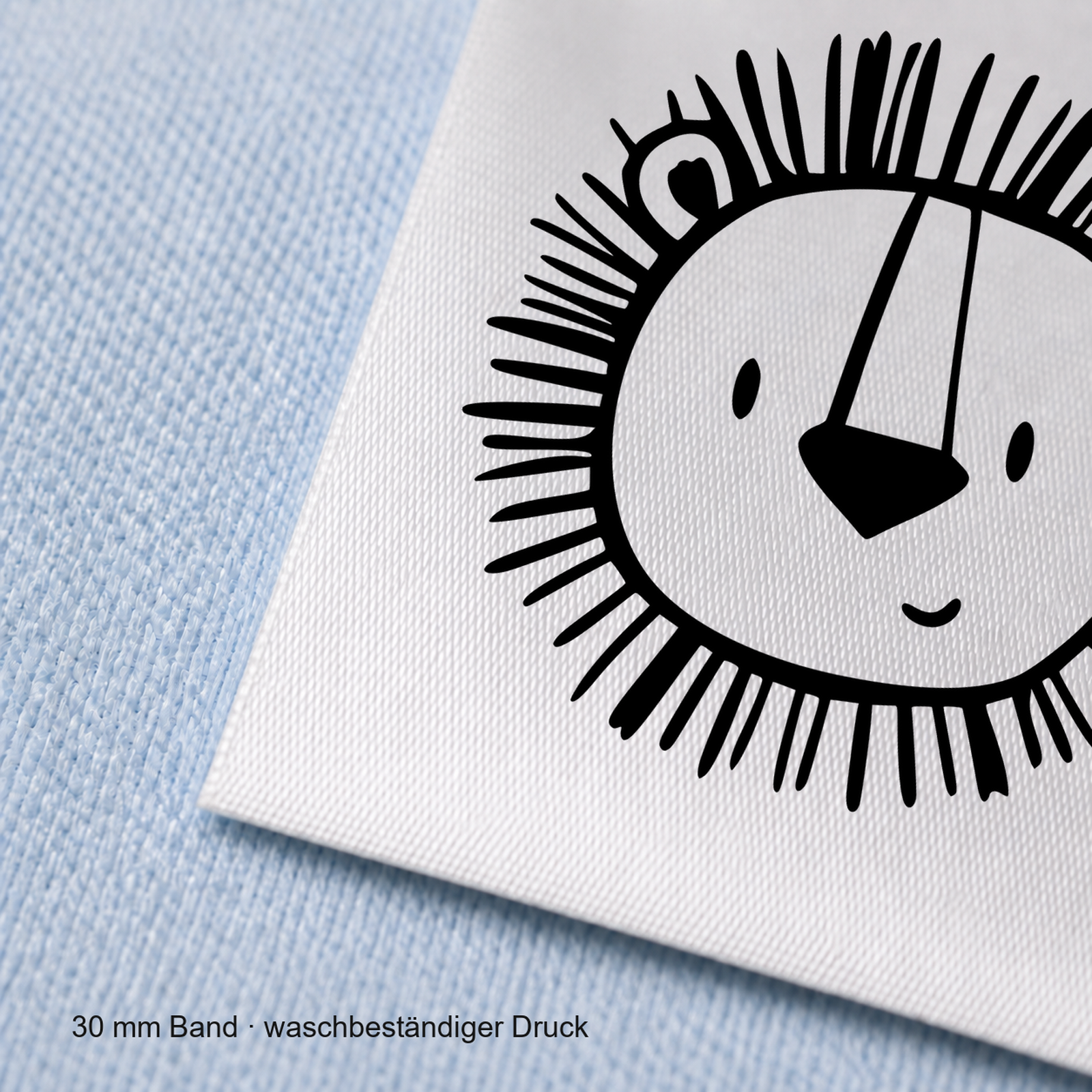 Textiletiketten mit Löwen Motiv zur Größenbeschriftung, Motiv von Näherei-Löwenjunges 6 Nahaufnahme eines bedruckten 30-mm-Polyester-Satinbands mit Motiv Löwe – Näherei Löwenjunges
