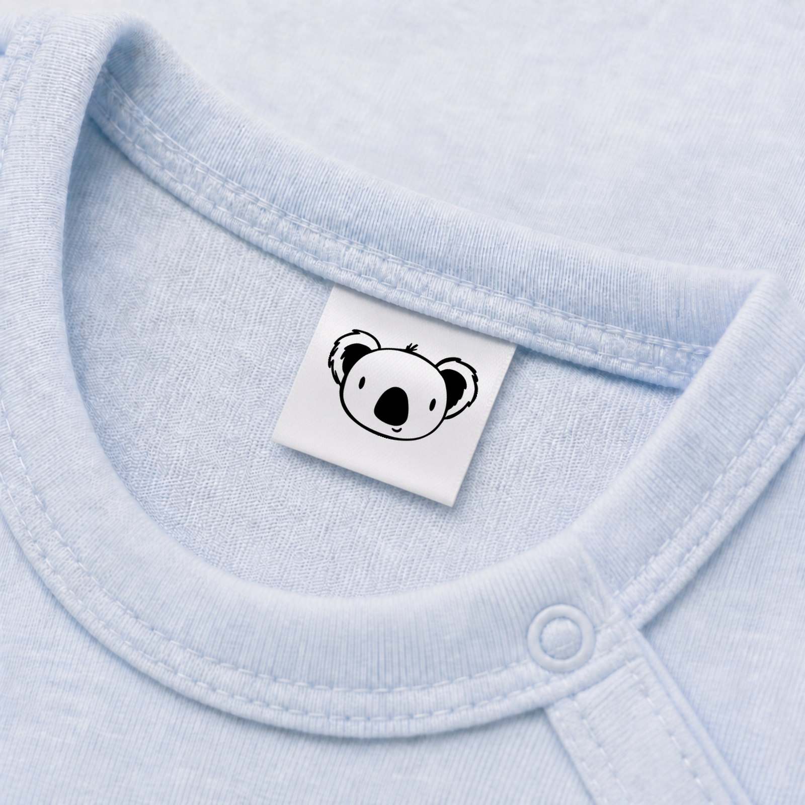 Textiletiketten mit Koala Bär Motiv zur Größenbeschriftung, Motiv von Näherei-Löwenjunges 5 Eingenähtes Polyester-Satinetikett mit Motiv Koala Bär in einem hellblauen Babybody