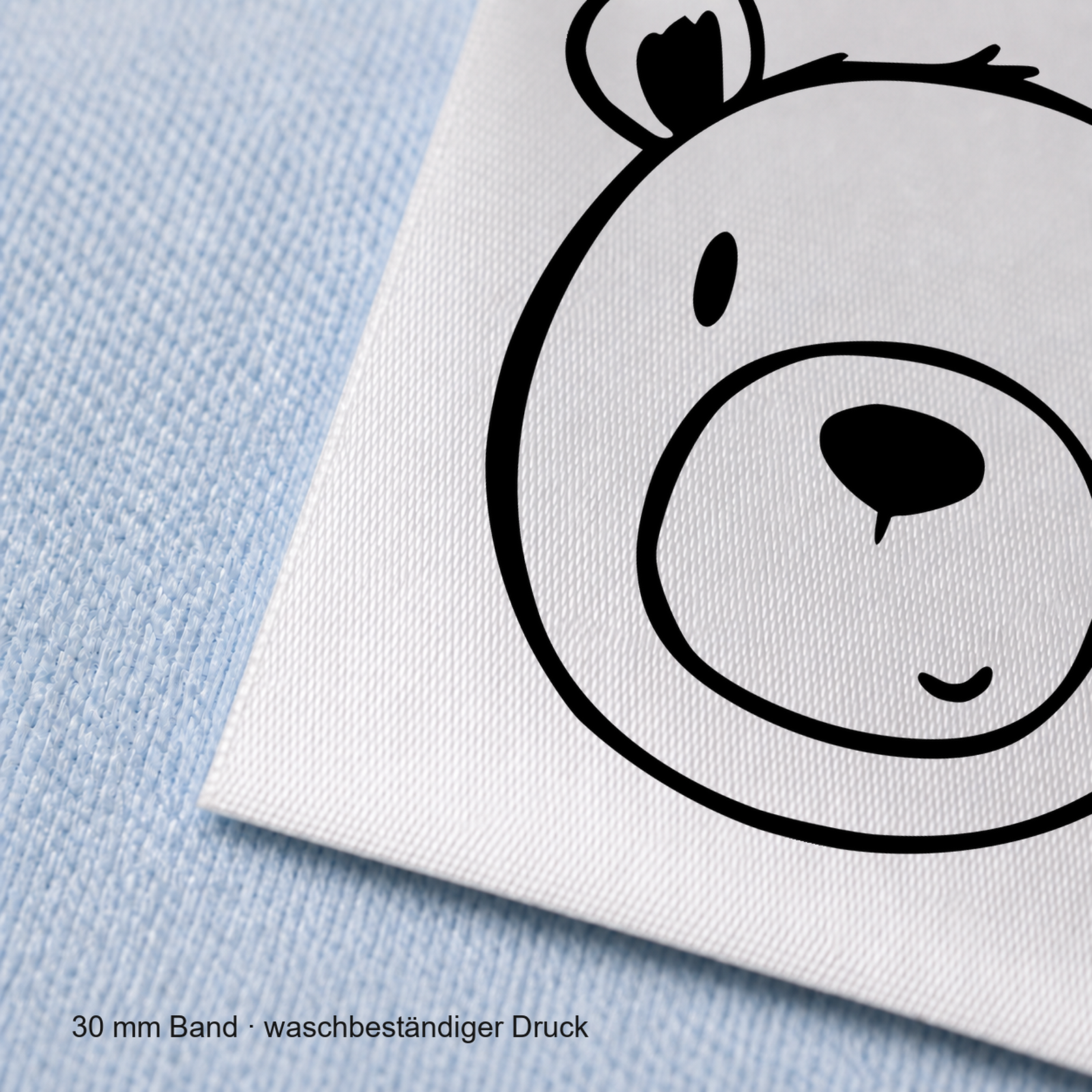 Textiletiketten mit Bär Motiv zur Größenbeschriftung, Motiv von Näherei-Löwenjunges 6 Nahaufnahme eines bedruckten 30-mm-Polyester-Satinbands mit Motiv Bär – Näherei Löwenjunges
