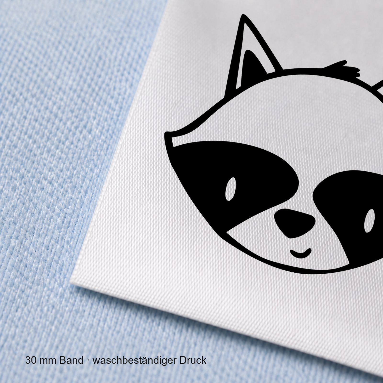 Textiletiketten mit Waschbär Motiv zur Größenbeschriftung, Motiv von Näherei-Löwenjunges 6 Nahaufnahme eines bedruckten 30-mm-Polyester-Satinbands mit Motiv Waschbär